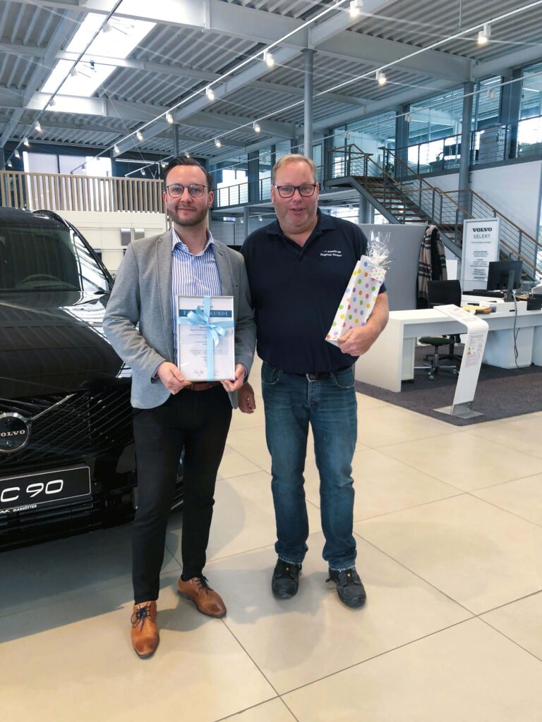 Zwei Männer, die Urkunde für Jubiläen halten